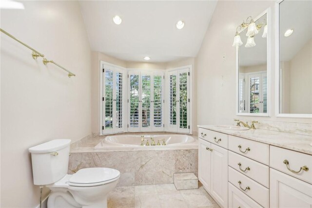 bathroom with tile patterned flooring, tiled bath, toilet, and vanity