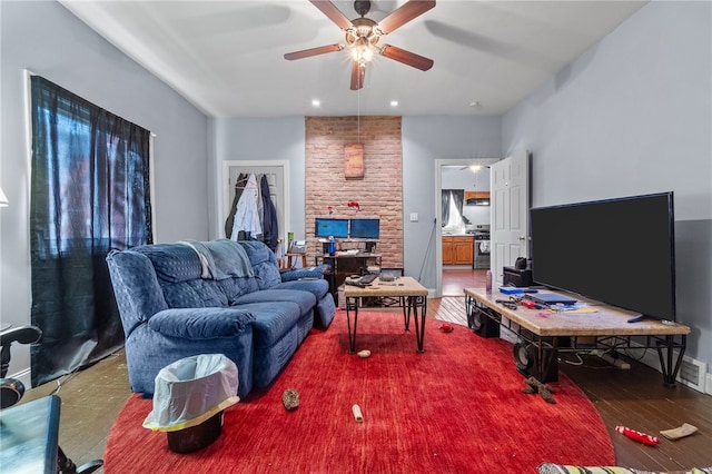 living room featuring hardwood / wood-style floors, ceiling fan, and brick wall