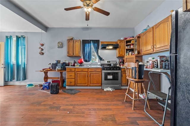 kitchen with wood-type flooring, ceiling fan, black refrigerator, and gas range