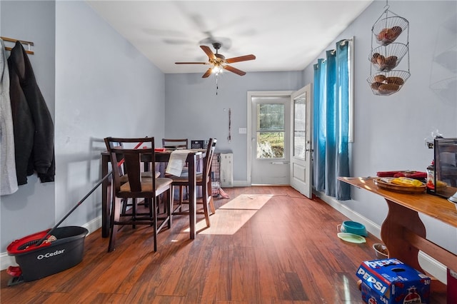 dining space featuring wood-type flooring and ceiling fan