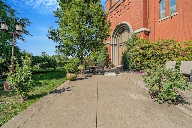 view of property's community with a lawn and a patio