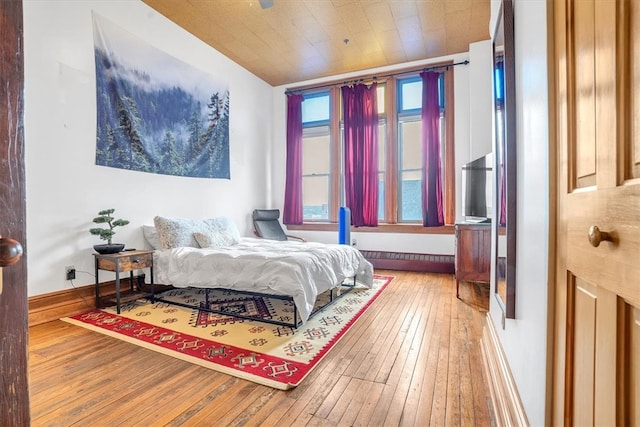 bedroom with wooden ceiling and hardwood / wood-style flooring