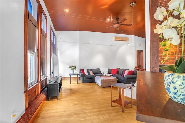 living room with lofted ceiling, ceiling fan, and light hardwood / wood-style floors