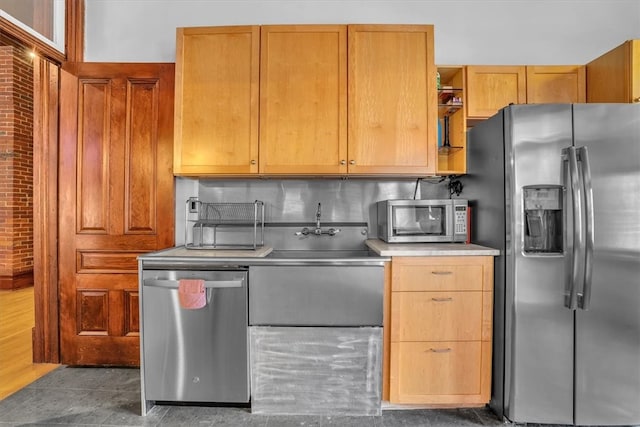 kitchen with sink, dark tile flooring, backsplash, and stainless steel appliances