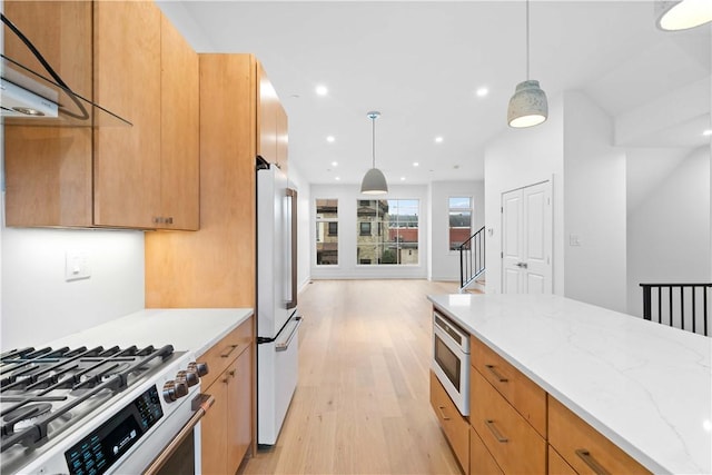 kitchen with built in microwave, hanging light fixtures, high end white refrigerator, and light stone countertops