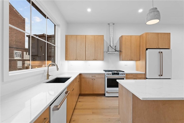 kitchen featuring high end fridge, sink, gas stove, hanging light fixtures, and dishwasher