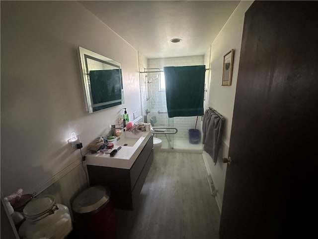 bathroom with vanity with extensive cabinet space, hardwood / wood-style flooring, and toilet