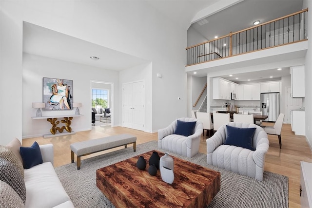 living room featuring light wood-type flooring and a high ceiling