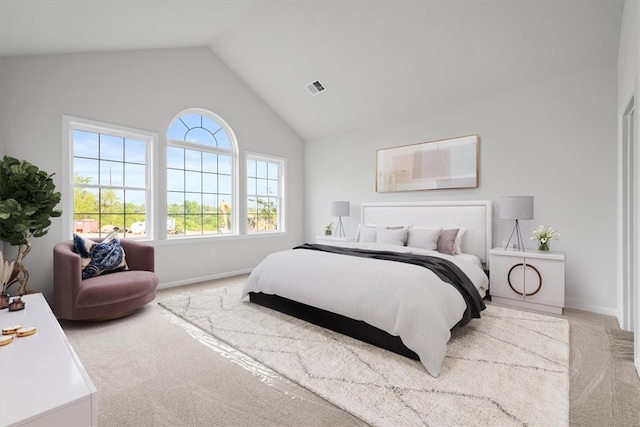 carpeted bedroom with high vaulted ceiling