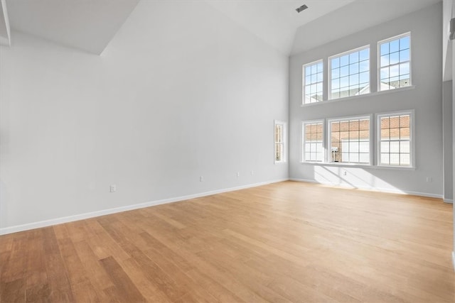 unfurnished room with high vaulted ceiling, light hardwood / wood-style floors, and plenty of natural light