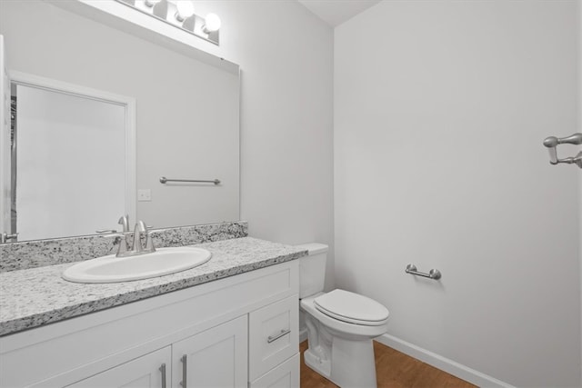 bathroom featuring wood-type flooring, vanity, and toilet