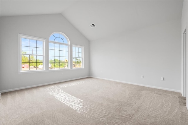 spare room with carpet flooring and high vaulted ceiling