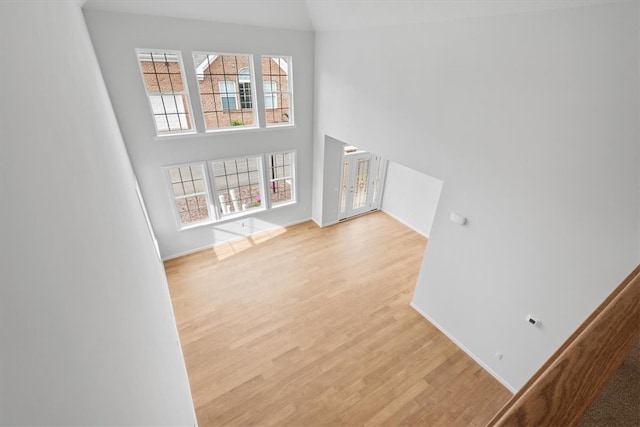 interior space featuring light wood-type flooring and a high ceiling