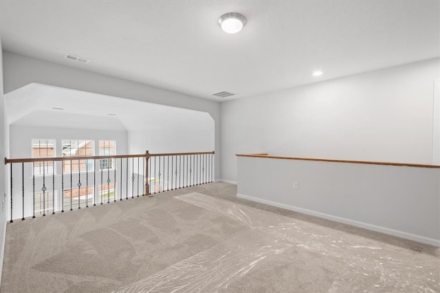 carpeted spare room with lofted ceiling