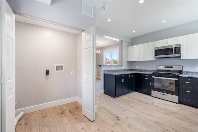 kitchen featuring appliances with stainless steel finishes, an inviting chandelier, light wood-type flooring, and white cabinetry