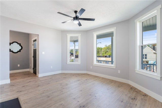 spare room with light hardwood / wood-style flooring, ceiling fan, and plenty of natural light