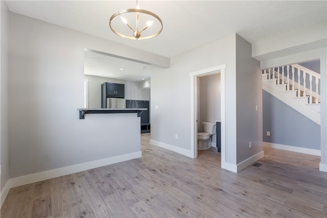 empty room featuring hardwood / wood-style floors and a chandelier