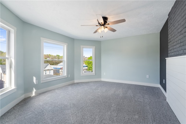 spare room featuring a textured ceiling, ceiling fan, and carpet flooring