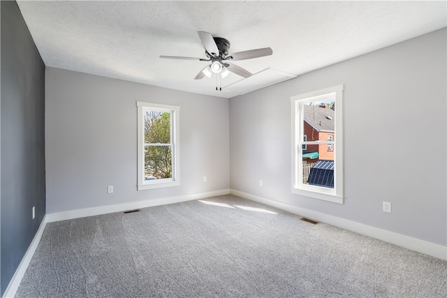 spare room with carpet flooring, ceiling fan, and a textured ceiling