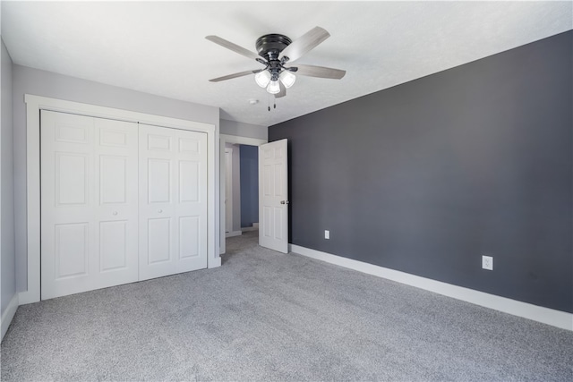 unfurnished bedroom with a closet, ceiling fan, and carpet flooring