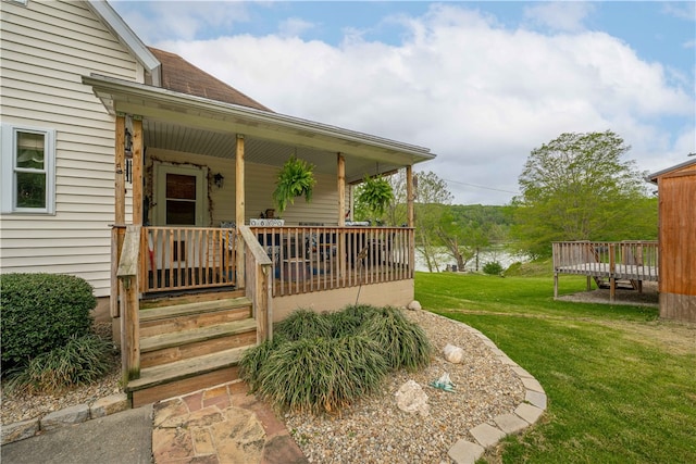 entrance to property featuring covered porch and a lawn