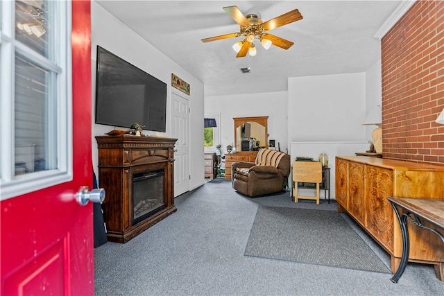 carpeted living room featuring brick wall and ceiling fan