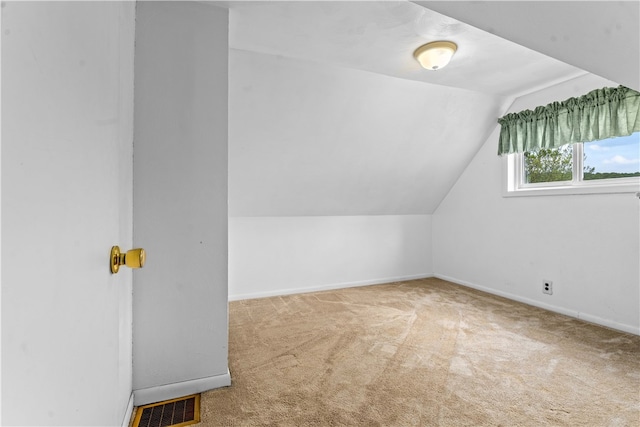 bonus room with vaulted ceiling and carpet floors