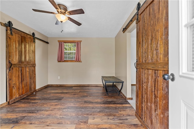 interior space with wood-type flooring and a barn door