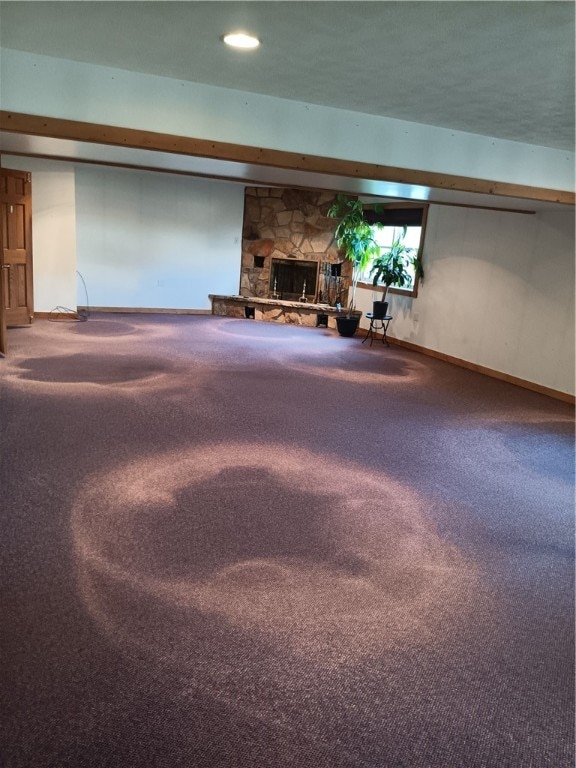 basement with a stone fireplace and carpet