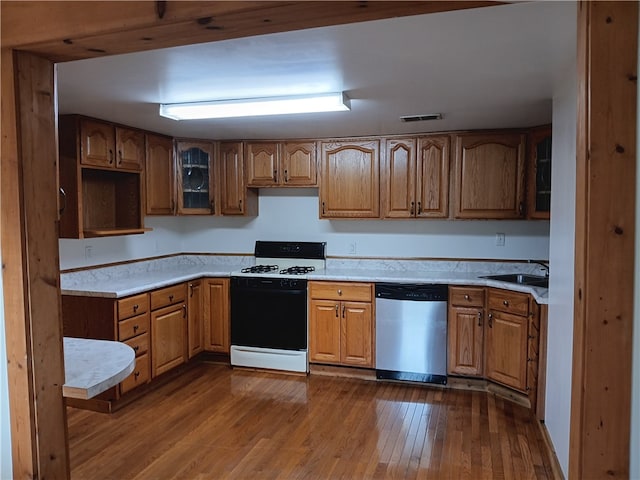 kitchen featuring white gas range, sink, wood-type flooring, and dishwasher