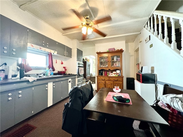 kitchen featuring carpet floors, ceiling fan, and oven