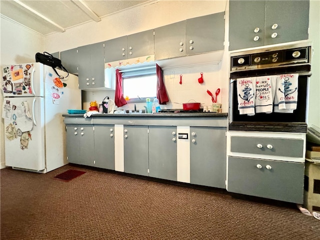 kitchen featuring white fridge, dark colored carpet, and black oven