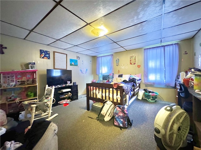 bedroom with a drop ceiling and carpet floors