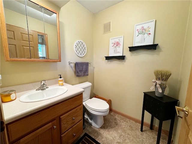 bathroom featuring tile flooring, vanity, and toilet