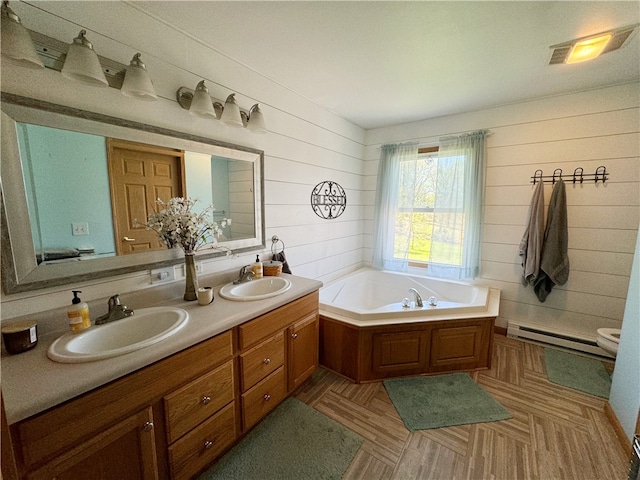 bathroom with a baseboard radiator, parquet floors, wood walls, a bath, and double sink