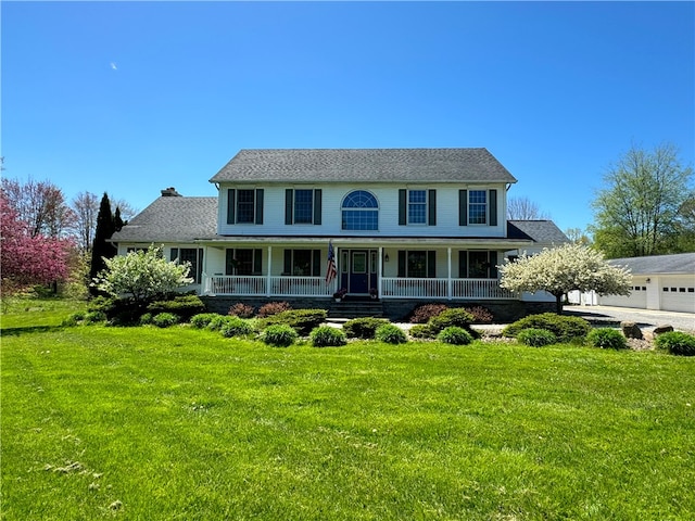 view of front facade featuring a garage, a front yard, and a porch