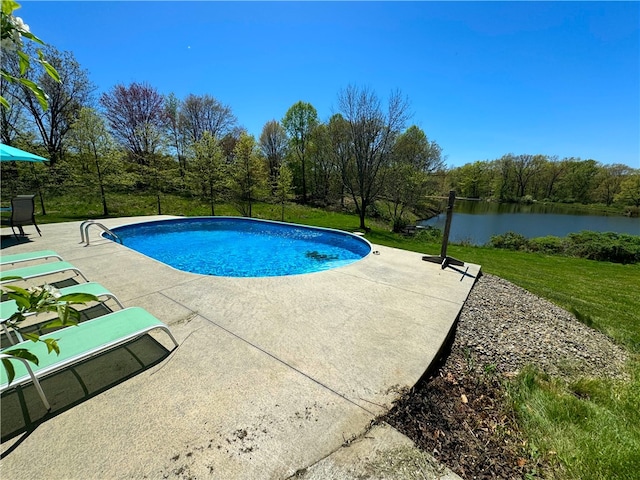 view of pool with a yard, a water view, and a patio area