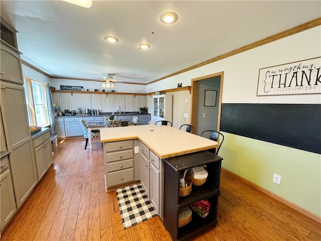 kitchen with ceiling fan, light hardwood / wood-style floors, and ornamental molding