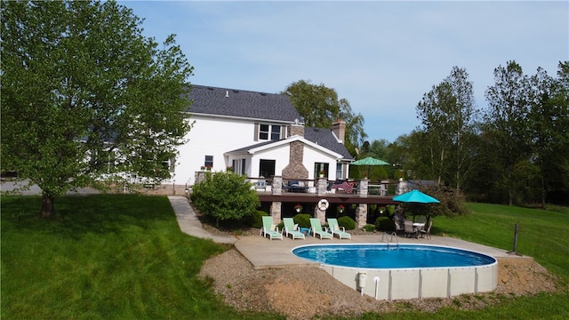 view of swimming pool with a deck, a lawn, and a patio