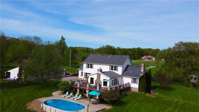 back of property featuring a lawn and a swimming pool side deck