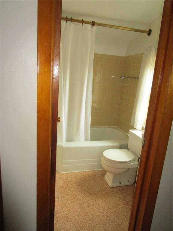 bathroom with shower / bathtub combination with curtain and toilet