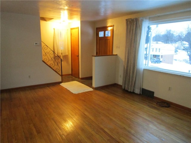 spare room featuring wood-type flooring and a healthy amount of sunlight