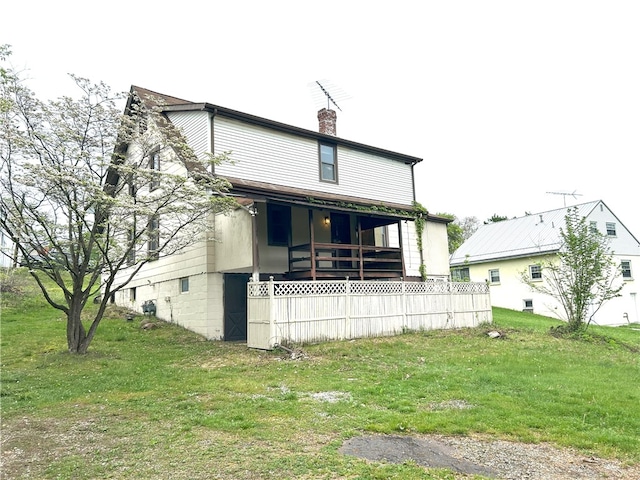 back of house featuring a lawn