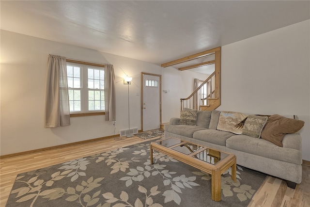 living room featuring beamed ceiling and hardwood / wood-style flooring