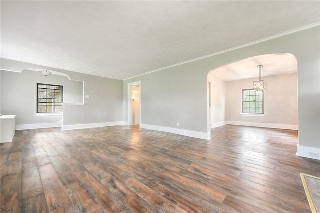 unfurnished room with ornamental molding and dark wood-type flooring