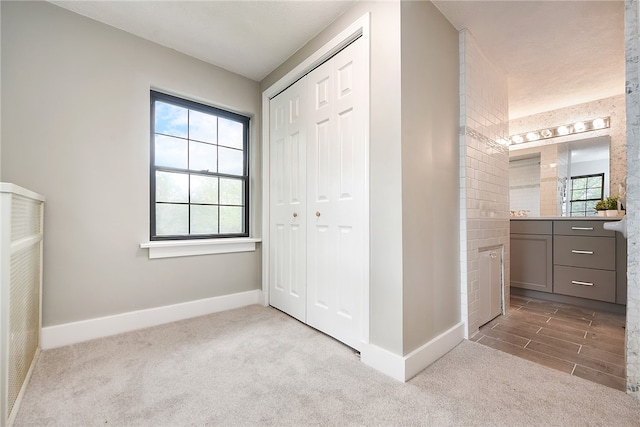 unfurnished bedroom featuring a closet, multiple windows, and light colored carpet