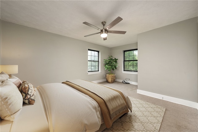 bedroom with ceiling fan, a textured ceiling, and carpet floors