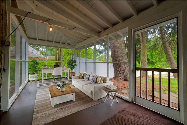 sunroom / solarium featuring vaulted ceiling with beams