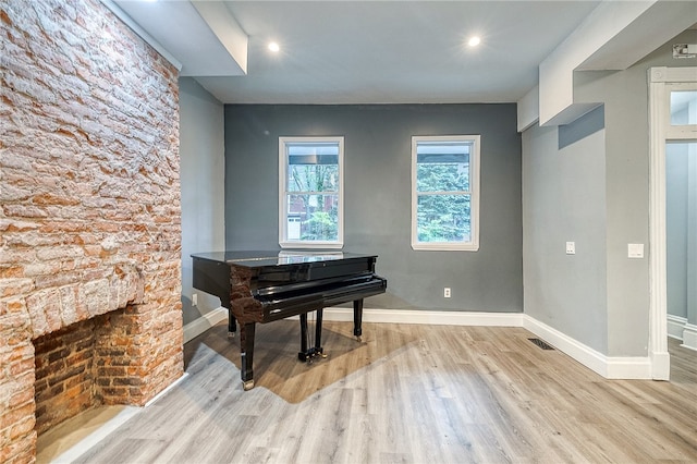 miscellaneous room with light hardwood / wood-style floors and a fireplace