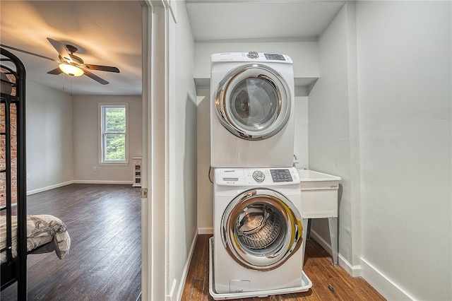 washroom featuring dark wood-type flooring, stacked washer and clothes dryer, and ceiling fan